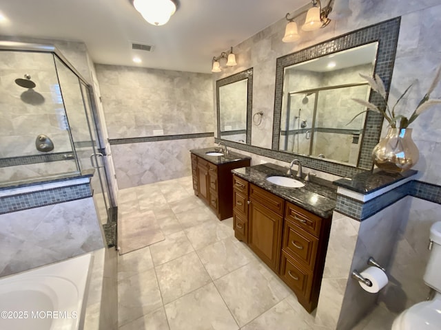 full bathroom featuring tile walls, vanity, and separate shower and tub