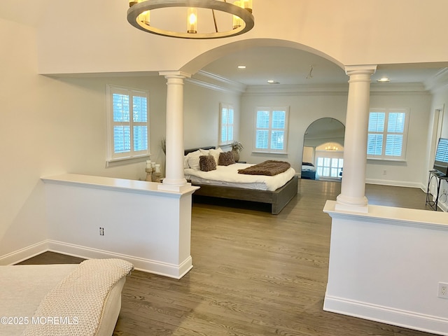 bedroom with ornate columns, ornamental molding, and dark hardwood / wood-style floors