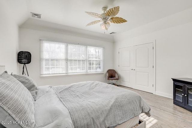 bedroom featuring ceiling fan, a closet, and light wood-type flooring