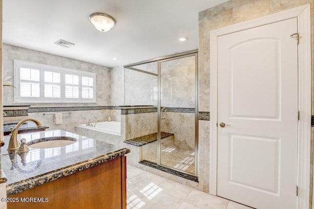 bathroom with vanity, an enclosed shower, tile patterned flooring, and tile walls