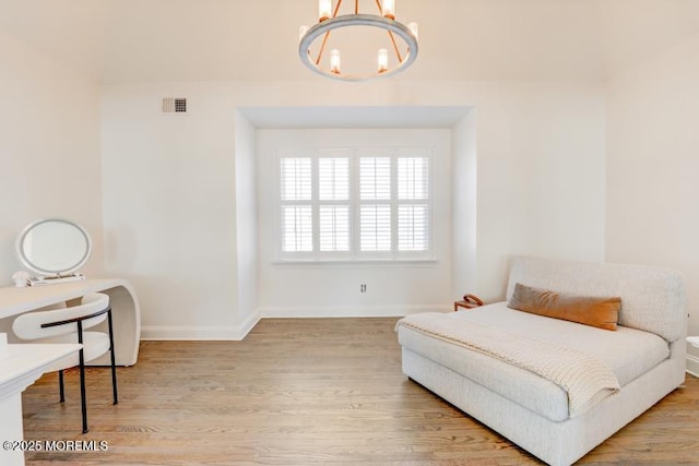 bedroom with an inviting chandelier and light wood-type flooring