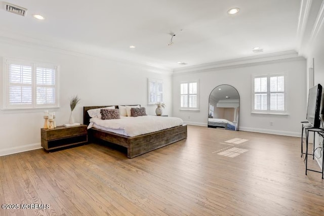 bedroom with ornamental molding, light hardwood / wood-style floors, and multiple windows