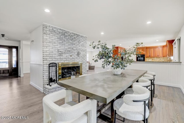 dining room with a fireplace and light hardwood / wood-style floors