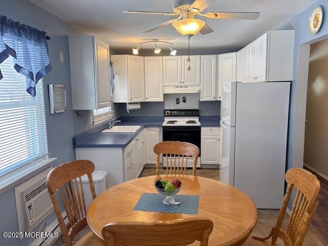 kitchen featuring white cabinetry, range with electric cooktop, white fridge, and sink