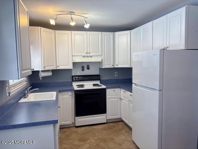 kitchen with range with electric stovetop, white fridge, sink, and white cabinets