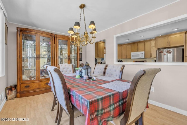 dining space featuring a notable chandelier and light hardwood / wood-style flooring