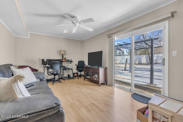 living room with hardwood / wood-style flooring, ceiling fan, and ornamental molding