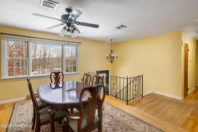 dining area with a baseboard radiator, hardwood / wood-style floors, and a notable chandelier