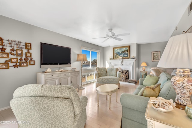 living room with ceiling fan and light hardwood / wood-style flooring