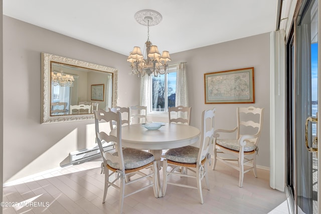 dining space featuring a baseboard heating unit and a notable chandelier