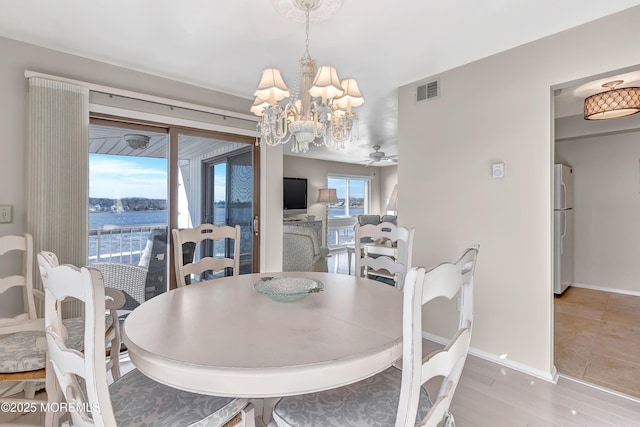 dining area with ceiling fan with notable chandelier