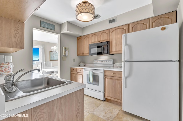 kitchen featuring sink, light brown cabinets, and white appliances