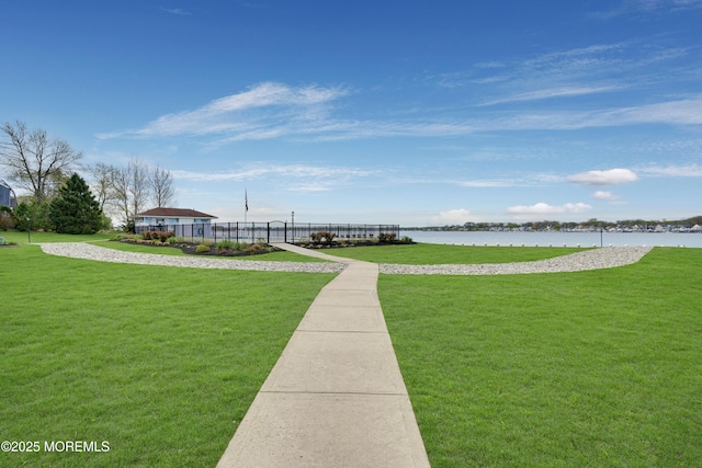 view of community with a yard and a water view