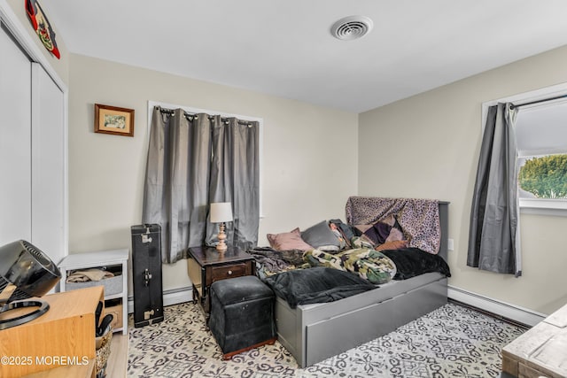 bedroom with a closet and a baseboard heating unit