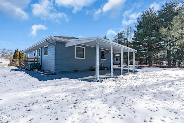 view of snow covered rear of property