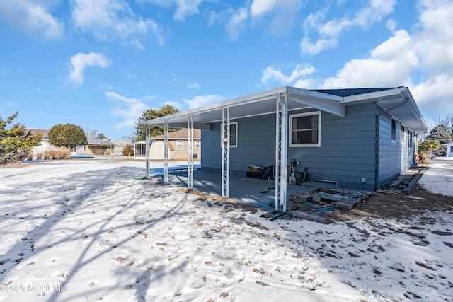 snow covered back of property with a storage shed