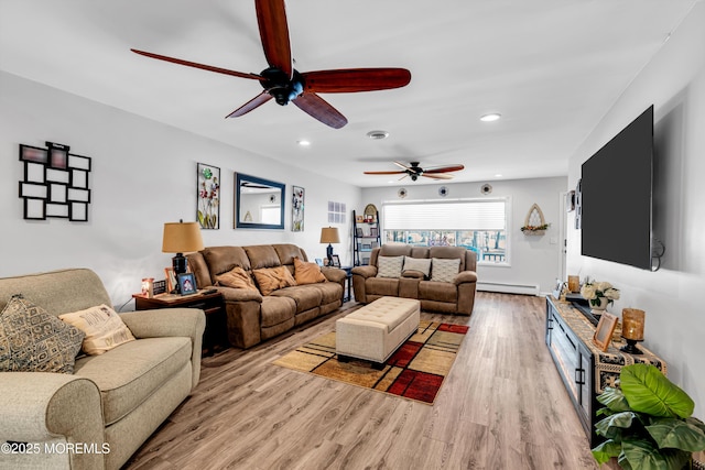 living room featuring baseboard heating and light hardwood / wood-style flooring