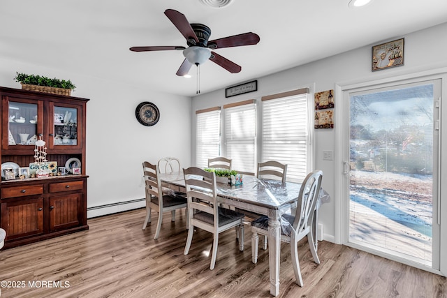 dining area featuring ceiling fan, light wood-type flooring, and baseboard heating