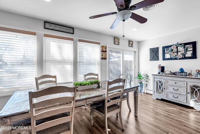 dining room featuring ceiling fan, light hardwood / wood-style floors, and a baseboard heating unit