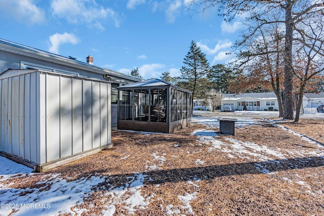 snowy yard featuring a sunroom