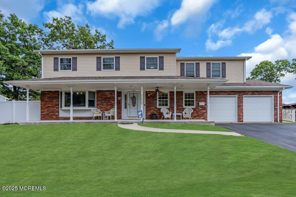 view of front of property with a porch, a garage, and a front yard