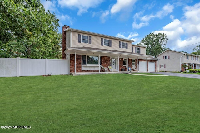 view of front facade with a garage, a front yard, and covered porch