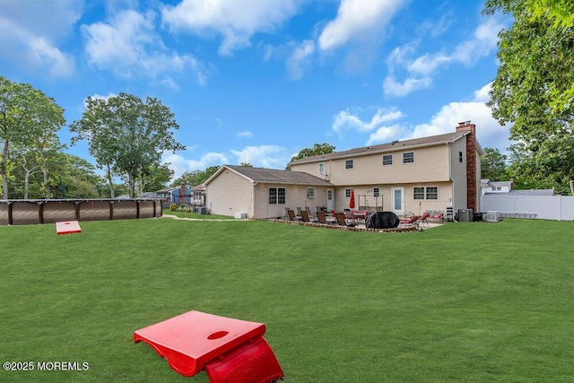 back of house featuring a fenced in pool, a lawn, a patio, and central air condition unit