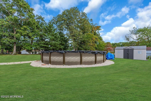 view of yard featuring a covered pool and a shed