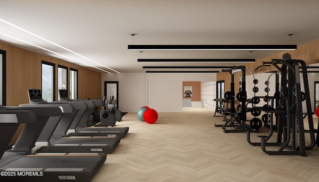 workout area featuring wood walls and light parquet floors