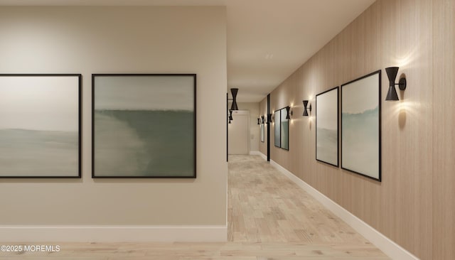 hall with light hardwood / wood-style flooring and wooden walls