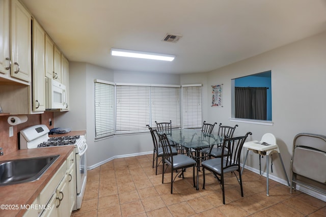 dining room featuring sink and light tile patterned flooring