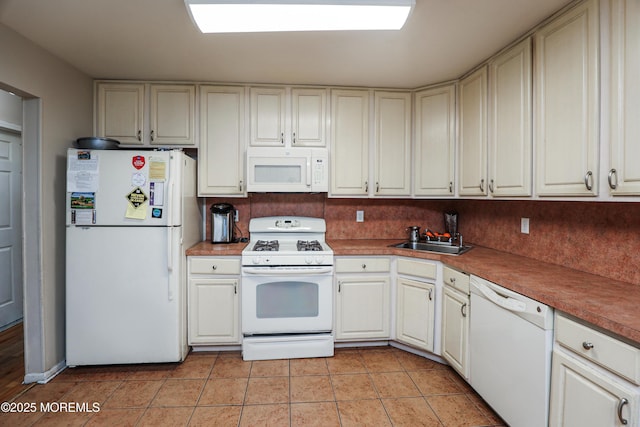 kitchen with light tile patterned flooring, white appliances, and sink