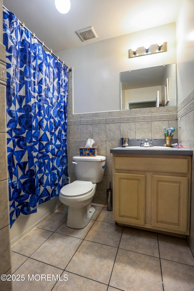 bathroom featuring tile walls, tile patterned flooring, vanity, walk in shower, and toilet