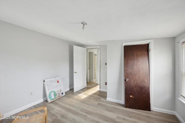 bedroom with light hardwood / wood-style floors and a closet