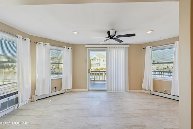 spare room featuring a baseboard radiator, a wealth of natural light, and ceiling fan