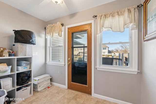 doorway featuring ceiling fan and light tile patterned floors