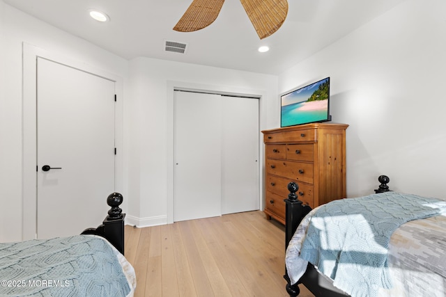 bedroom with ceiling fan, light hardwood / wood-style floors, and a closet