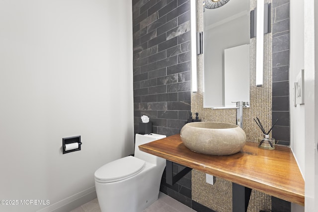 bathroom with toilet, sink, and backsplash