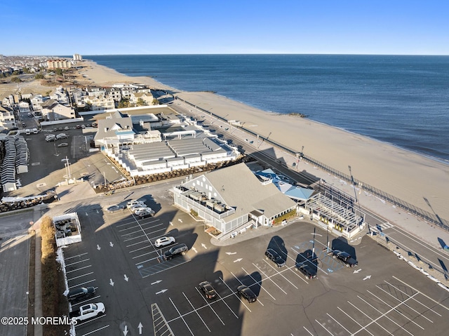 drone / aerial view featuring a water view and a view of the beach