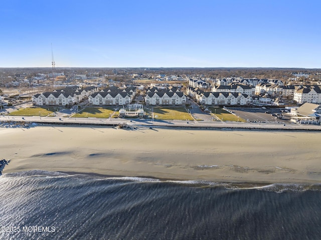 bird's eye view featuring a water view and a beach view