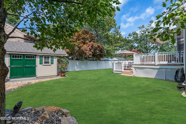 view of yard featuring a wooden deck and a storage unit