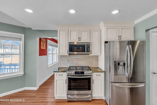 kitchen with white cabinetry, stainless steel appliances, and dark stone counters