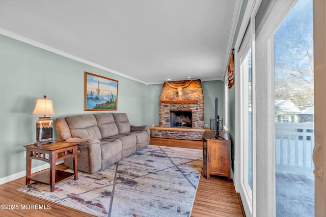 living room featuring hardwood / wood-style floors, crown molding, and a fireplace