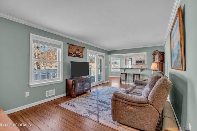 living room featuring hardwood / wood-style flooring and crown molding