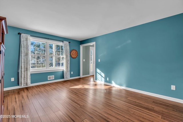 empty room with hardwood / wood-style flooring