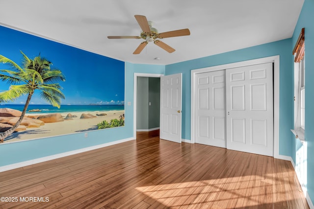 unfurnished bedroom with ceiling fan, hardwood / wood-style floors, and a closet