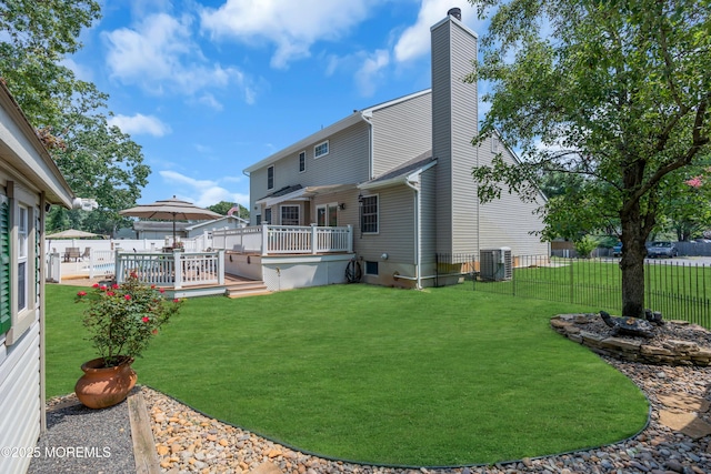 back of property with a yard, central AC, and a deck