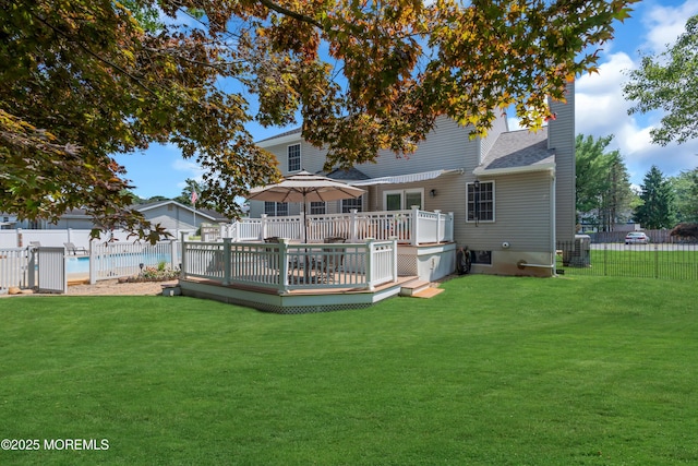 rear view of property featuring central AC unit, a yard, and a deck