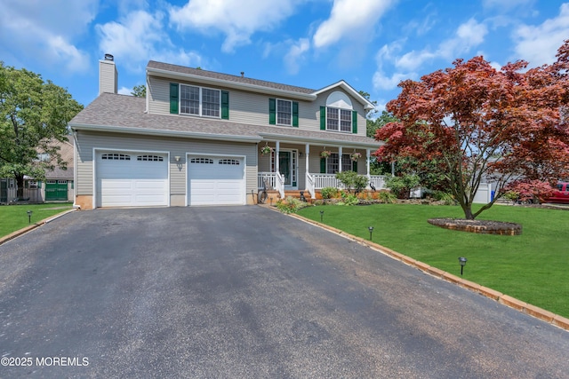 front of property with a garage, a front lawn, and a porch