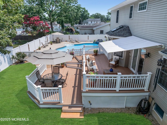 view of swimming pool featuring a lawn and a deck